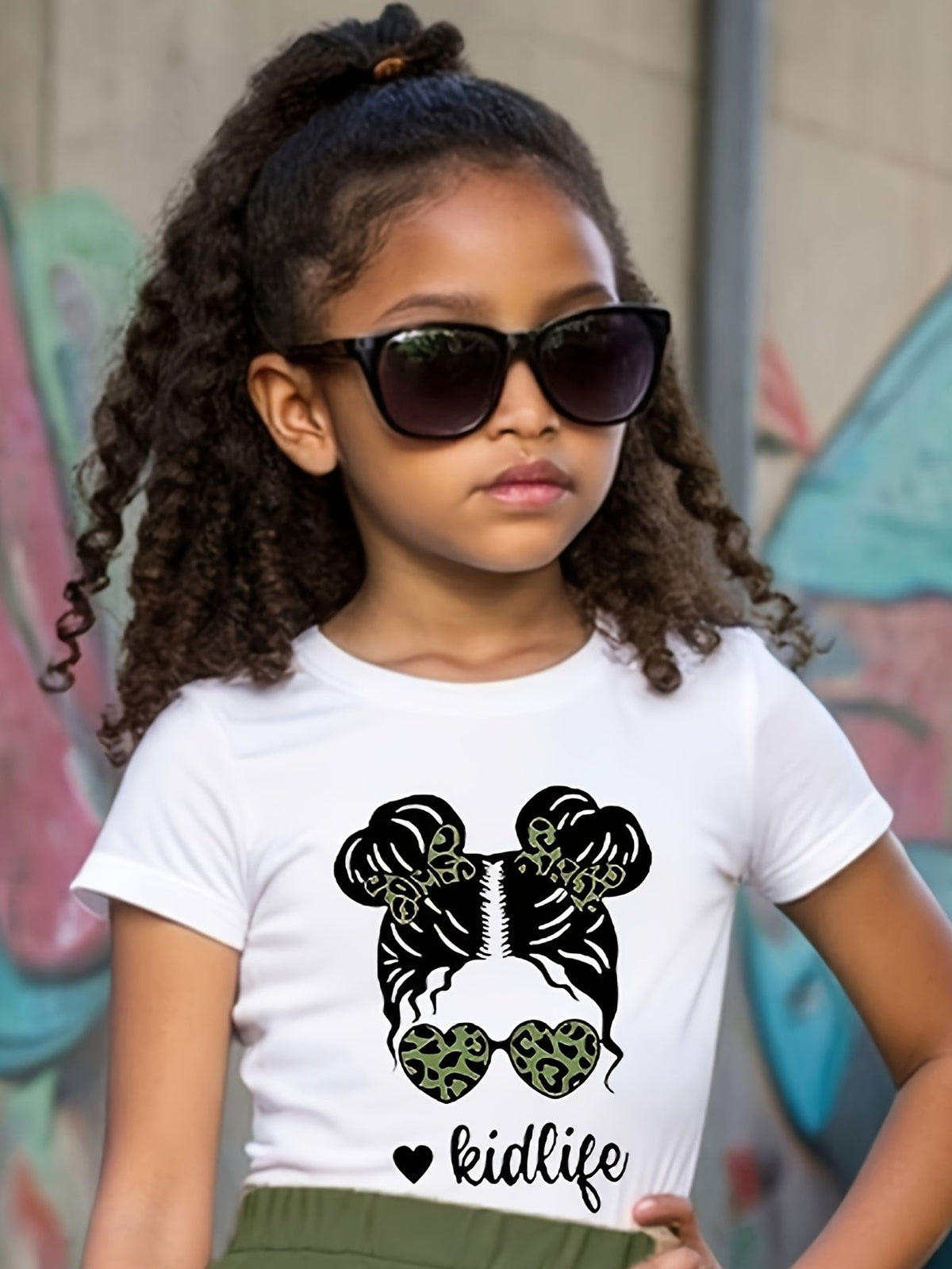 Girls' White Cotton Kidlife Graphic T-Shirt with Hair Buns and Leopard Sunglasses for Casual Summer Wear